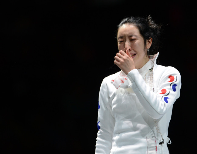 2012 런던올림픽 펜싱대표팀의 신아람이 30일 런던의 엑셀 런던의 사우스 아레나에서 열린 여자 에페 준결승에서 브리타 하이데만(독일)과 연장까지 가는 접전을 펼친 끝에 석연치 않은 판정으로 패한 뒤 경기가 진행된 코트에 주저 앉아 재심을 기다리던 중 관계자들에게 코트 밖으로 이끌리며 눈물을 쏟고 있다. 이날 경기는 1초를 남겨둔 상황에서 하이데만이 마지막 3번의 공격을 하는 동안 1초의 시간이 흐르지 않아 논란을 남겼고, 한국팀은 30여분 동안 강력히 항의했지만 결국 받아들여지지 않았다. 120730 런던=올림픽사진공동취재단j