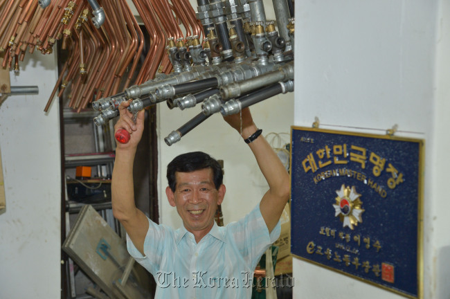 이영수 보일러 명장<br />김명섭 기자 msiron@
Lee Young-soo grabs a boiler pipe.  Kim Myung-sub/The Korea Herald