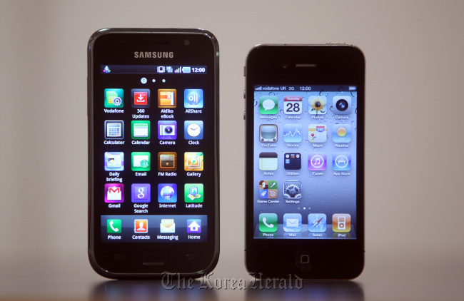 A Samsung Galaxy smartphone (left) and an Apple Inc. iPhone 4 sit arranged for a photograph at a mobile phone store in London.
Bloomberg