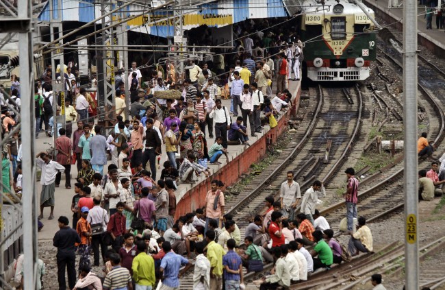 Stranded passengers wait on a platform and some of them on rail tracks for train services to resume following a power outage at Sealdah station in Kolkata, India, Tuesday.  AP-Yonhap News