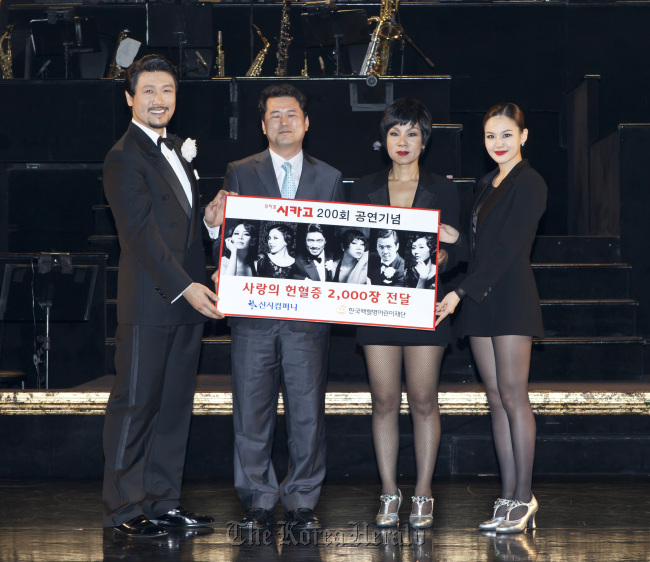 The cast of the Broadway musical “Chicago,” Sung Gi-yoon (left), Insooni (second from right) and Ivy (right) deliver 2,000 blood donor cards to Seo Sung-won of the Korea Childhood Leukemia Foundation on July 29. Seensee Company