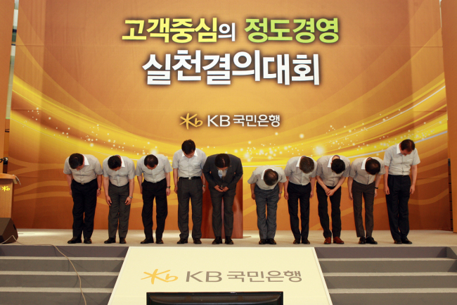 <YONHAP PHOTO-1673> KB국민은행 고객중심의 정도경영 실천선언 (서울=연합뉴스) KB국민은행은 1일 오후 경영진과 부점장 1,260명 전원이 천안연수원에 모여 고객중심의 정도경영 실천 선언식을 갖고 사회구성원과 고객, 임직원 모두에게 희망을 주는새로운 KB국민은행으로 다시 태어날 것을 서약했다. 2012.8.1 << KB국민은행 >> photo@yna.co.kr/2012-08-01 17:25:43/ <저작권자 ⓒ 1980-2012 ㈜연합뉴스. 무단 전재 재배포 금지.>
KB Kookmin Bank CEO Min Byong-deok (fifth from left) and other executives take a deep bow after pledging to regain customers’ confidence at a ceremony in Cheonan, South Chungcheong Province, Wednesday.     KB Kookmin Bank