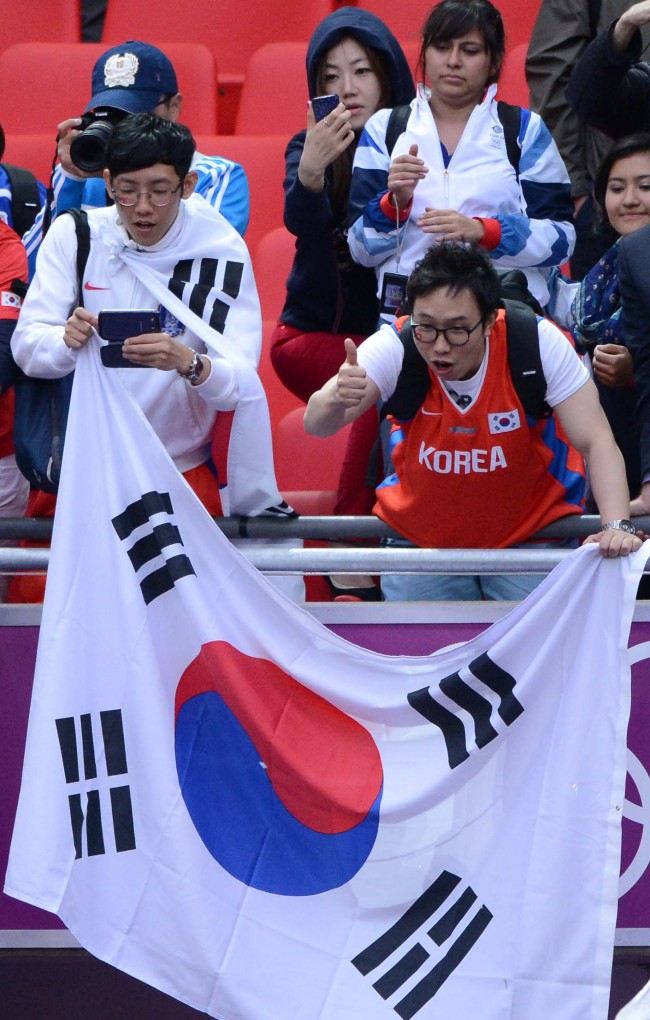 South Korean supporters cheer on their team after the match against Gabong on Wednesday. (London Olympic Joint Press Corps)