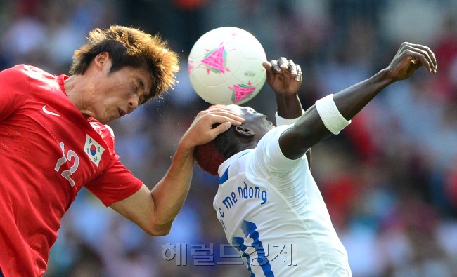 런던올림픽 축구 조별리그 마지막 가봉과 경기에서 홍명보 호의 중앙수비수 황석호(왼쪽)가 메이에와 공중볼 경합을 벌이던 중 상대 머리를 잡고 있다. [런던=올림픽사진공동취재단]