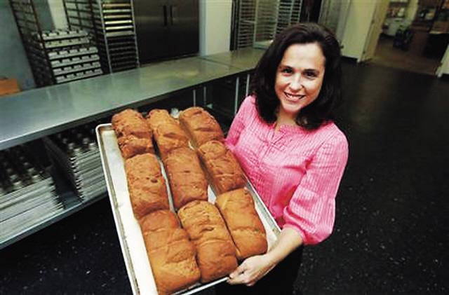 Michele Kelly, owner of Pure Knead bakery, poses with a rack of freshly baked gluten-free sandwich bread in Decatur, Georgia. (AP)