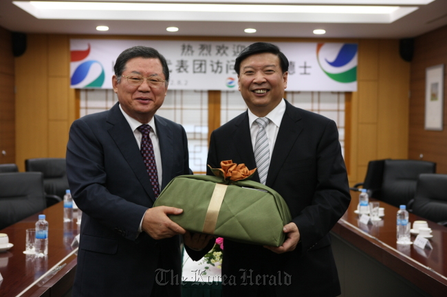 GS Caltex chairman Hur Dong-soo (left) and China’s Shandong Province governor Jiang Daming pose at the oil refiner’s plant in Yeosu, South Jeolla Province, on Thursday.  GS Caltex