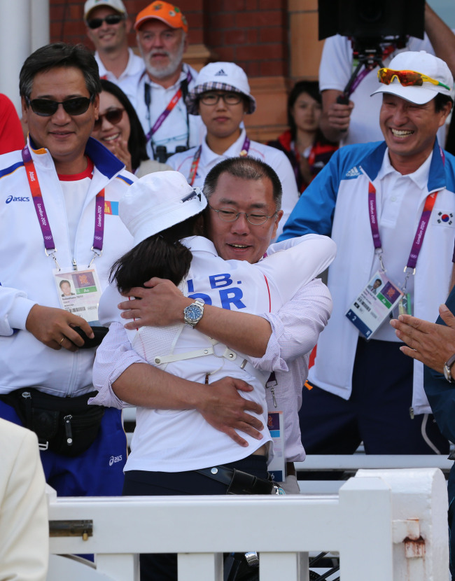 <YONHAP PHOTO-0117> <올림픽>양궁장 찾은 정의선 (런던=연합뉴스) 서명곤 기자 = 2일 오후(현지시간) 런던 로즈 크리켓 그라운드에서 열린 2012런던올림픽 여자 양궁 개인전 결승에서 정의선 현대차그룹 부회장이 금메달을 차지한 기보배를 안아주고 있다. 2012.8.3 seephoto@yna.co.kr/2012-08-03 01:03:27/ <저작권자 ⓒ 1980-2012 ㈜연합뉴스. 무단 전재 재배포 금지.>
Hyundai Motor Group vice chairman Chung Eui-sun, who serves as head of the Korea Archery Association, congratulates Ki. London Olympic Joint Press Corps