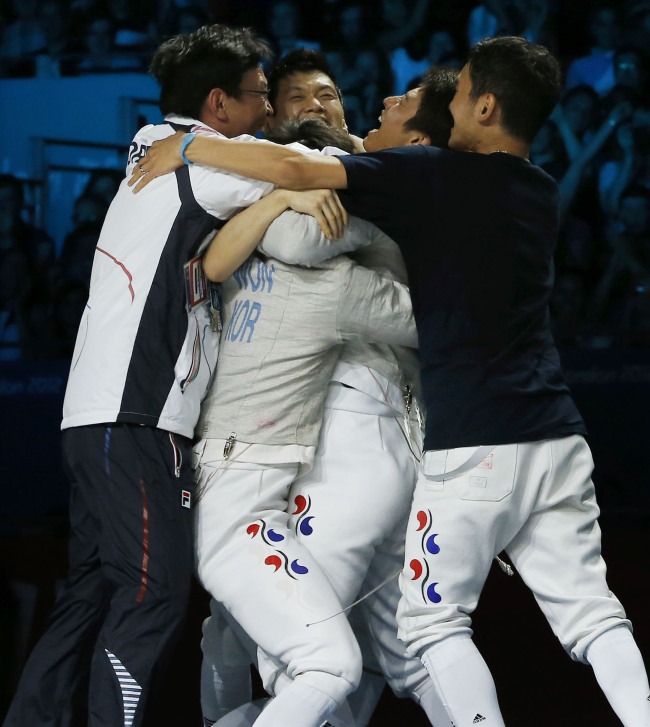 South Korean fencing team cheers after winning the gold medal in men's team saber fencing event at the 2012 London Olympics on Friday. (Yonhap News)