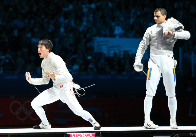 South Korean sabre fencer Won Woo-young (left) reacts after winning the gold medal at 2012 London Olympics on Friday. (Yonhap News)