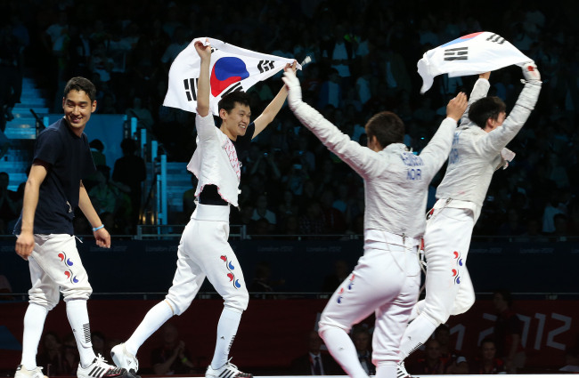 South Korean sabre fecing team cheers after beating Romania to claim gold medal at the 2012 London Olympic Games. The victory marked the country's 100th Olympic gold medal. (Yonhap News)