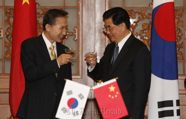 President Lee Myung-bak (left) and his Chinese counterpart Hu Jintao share a toast during a dinner party in Beijing in May.   The Korea Herald