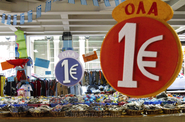 One euro price signs hang over discounted goods on sale at a store in Athens.  Bloomberg