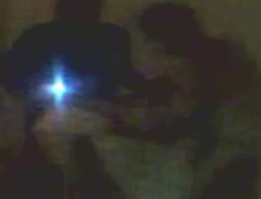 A police officer beats Mumtaz Mirbahar (right) and forces him to take off his clothes in this cellphone video footage. (Image from YouTube-BBC)