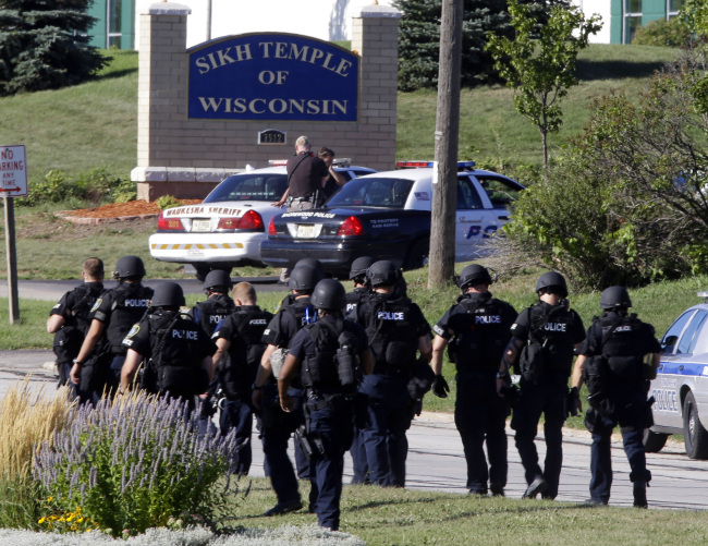 Police walk near the Sikh Temple of Wisconsin in Oak Creek, Wisconsin, after a shooting on Sunday.  AP-Yonhap News