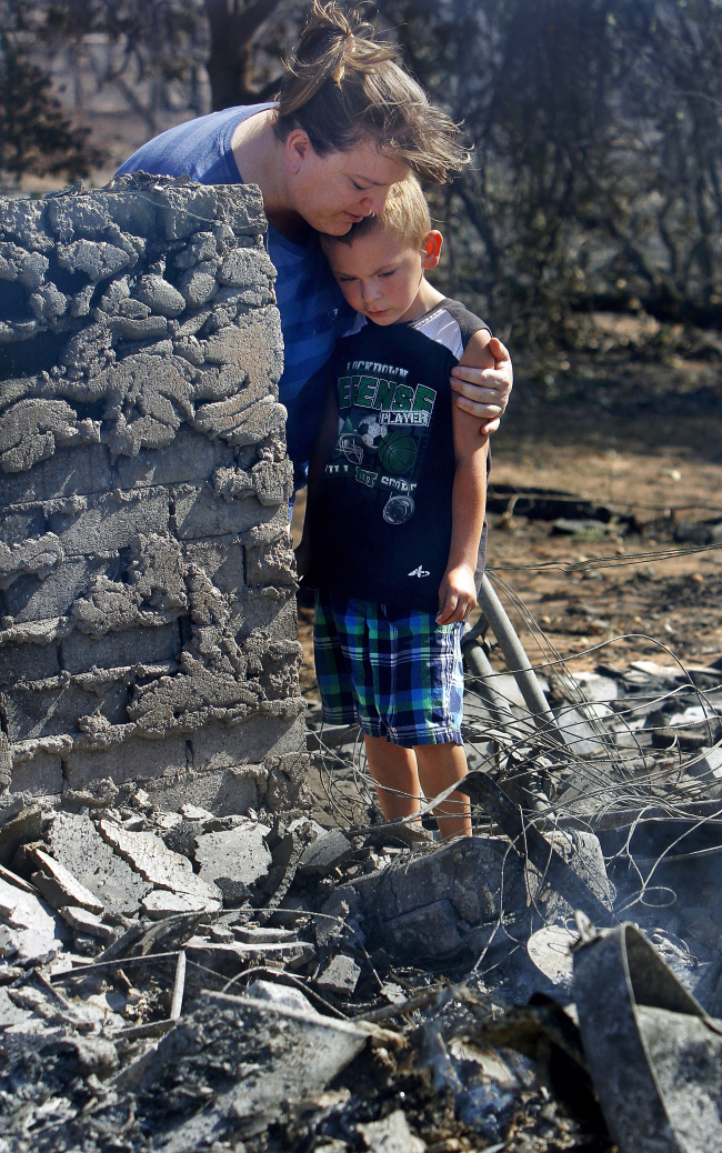 Tracy Streeper hugs 5-year-old grandson Jesse, as they stand on the north side of Streeper’s destroyed home in Luther, Oklahoma, Saturday.  AP-Yonhap News