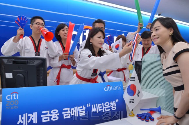 8일 오전 한국씨티은행 명동중앙지점에서 직원들이 2012 런던올림픽 태권도 금메달 획득을 기원하며 태권도복을 입고 화이팅을 외치고 있다. 이날 직원들은 유니폼 대신 태권도복을 압고 근무하며 지점을 방문한 고객들에게 응원도구를 나눠줄 예정이다.<br />이상섭 기자. babtong@heraldm.com 2012.08.08
8일 오전 한국씨티은행 명동중앙지점에서 직원들이 2012 런던올림픽 태권도 금메달 획득을 기원하며 태권도복을 입고 화이팅을 외치고 있다. 이날 직원들은 유니폼 대신 태권도복을 압고 근무하며 지점을 방문한 고객들에게 응원도구를 나눠줄 예정이다.
이상섭 기자. babtong@heraldm.com 2012.08.08