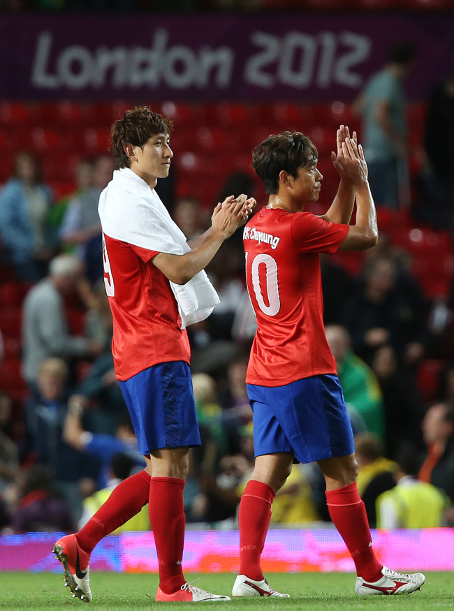 Ji Dong-won (left) and Park Chu-young of Korea leave the pitch after their loss to Brazil on Tuesday.   London Olympic Joint Press Corps