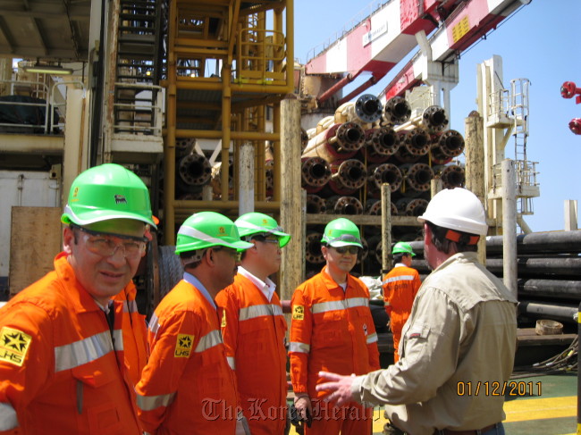 Lee Jong-ho (fourth from left), chief of the resources development division at KOGAS, is briefed on finding natural gas on a drilling ship in waters off Mozambique last year.  KOGAS