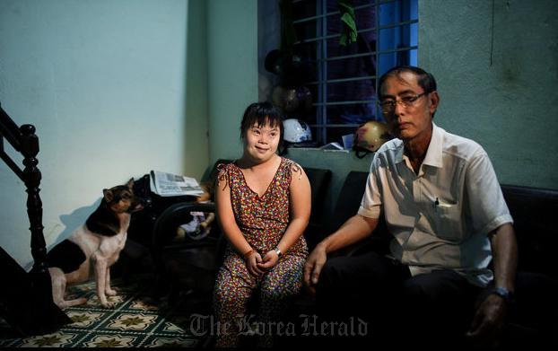 Vo Thi Thuy Nga (left) and her uncle Vo Duoc sit inside their home in Danang, Vietnam.  AP-Yonhap News