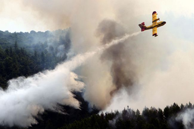 <YONHAP PHOTO-0143> A waterbomber drops water over a wildfire in Ouranoupoli, northern Greece, on August 9, 2012. Around 25 fire units are battling the blaze which broke out on August 8 in the heart of Mount Athos. Five planes and two helicopters have been called in to help quench the blaze. The fire initially broke out on August 8 in the heart of Mount Athos, which is home to around 20 Greek Orthodox monasteries, which are not directly threatened by the flames, fire officers said. AFP PHOTO / STRINGER../2012-08-10 02:13:33/ <저작권자 ⓒ 1980-2012 ㈜연합뉴스. 무단 전재 재배포 금지.>
A waterbomber drops water over a wildfire in Ouranoupoli, northern Greece, on Friday.   AFP-Yonhap News