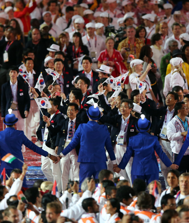 <YONHAP PHOTO-0162> <올림픽>입장하는 한국 선수단 (런던=연합뉴스)이상학 기자 = 제30회 런던하계올림픽 폐막식이 12일 오후(현지시각) 영국 런던 북동부 리밸리의 올림픽스타디움에서 열렸다. '영국 음악의 향연(a symphony of British music)'이라는 주제 속에 폐막식이 진행되는 가운데 한국 선수단이 입장하고 있다. 한국 선수단이 2012년 런던올림픽에서 금 13개·은 8개·동 7개(총 28개)로 종합 5위에 올라 역대 원정 올림픽 최고 순위를 기록하며 성공적으로 대회를 마쳤다. .2012.8.13 leesh@yna.co.kr/2012-08-13 06:11:37/ <저작권자 ⓒ 1980-2012 ㈜연합뉴스. 무단 전재 재배포 금지.>
The South Korean squad enters Olympic Stadium during the closing ceremony on Sunday.
London Olympic Joint Press Corps