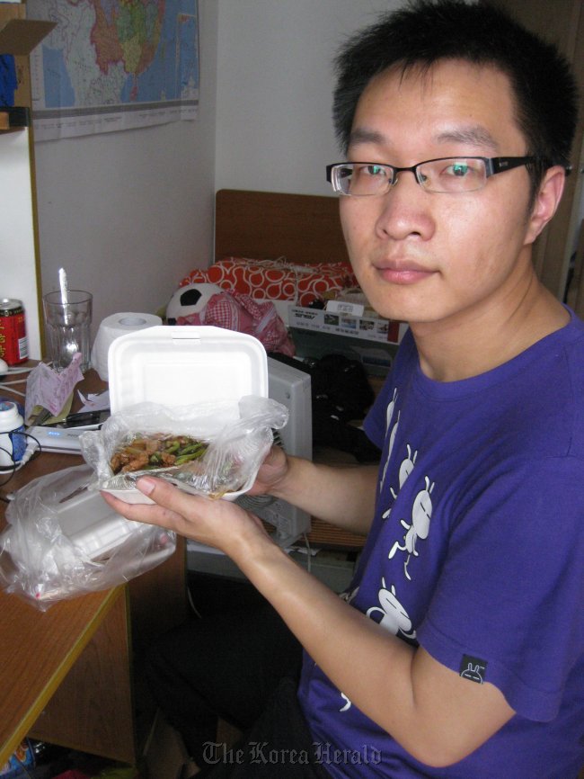 Wu Heng with a packet of the kind of cheap beef rice which he ate almost every day over six months.  The Straits Times