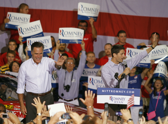 Republican presidential candidate Mitt Romney (left) waves as his vice presidential running mate Rep. Paul Ryan, of Wisconsin, speaks during a campaign rally at the NASCAR Technical Institute in Mooresville, North Carolina, Sunday.   AP-Yonhap News