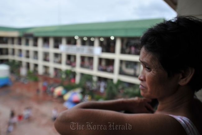 A flood affected resident looks from a window of a school building serving as an evacuation center in Marikina town, suburban Manila on Aug. 9. AFP-Yonhap News