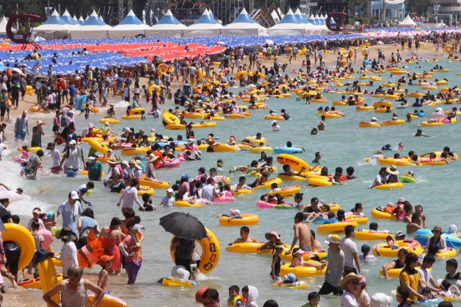 Holidaymakers crowd Haeundae beach earlier this month.   Yonhap News