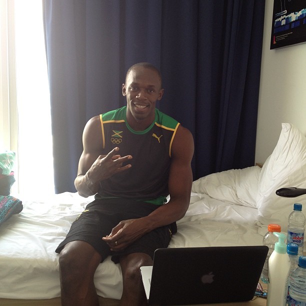 Usain Bolt poses at the camera, holding up three fingers in "W" shape (Twitter)