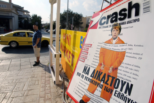 German Chancellor Angela Merkel is seen as a prisoner with handcuffs on the cover page of the Greek magazine Crash with the headline reads “Lagarde, Merkel, Soible, Barroso, Robey: They should be tried for genocide of the Greeks” in Athens.   AP-Yonhap News
