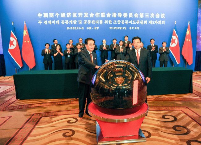 Jang Song-thaek (left) North Korea’s vice chairman of the powerful National Defense Commission, and Chinese Minister of Commerce Chen Deming attend the third meeting of the joint steering committee for developing and managing the special economic zones in North Korea, in Beijing on Tuesday.   Xinhua News