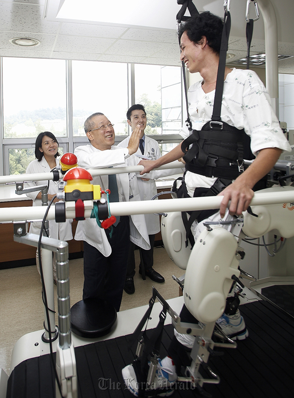 Doctors at Yonsei University’s Severance Hospital watch Truong Vinh Thuan receive robot-assisted gait training during his rehabilitation.  Kumho Tire