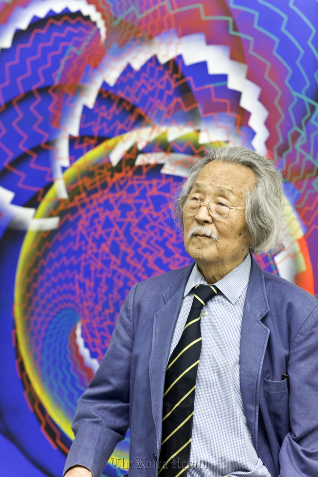The 99-year-old artist Han Mook poses in front of his painting at the Gallery Hyundai Gangnam in Seoul last week.   Gallery Hyundai