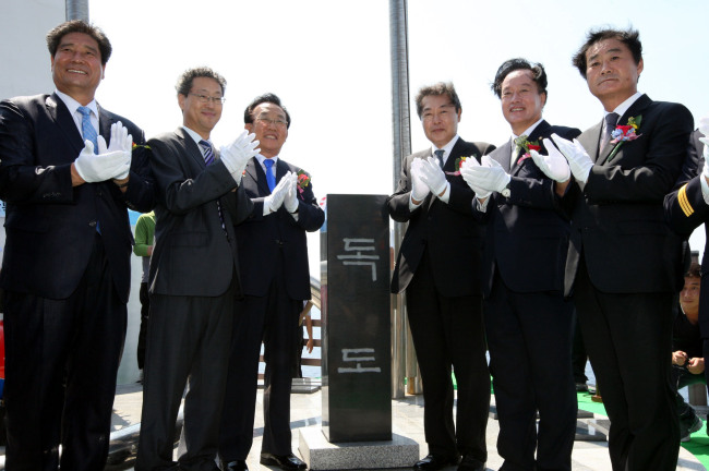 Public Administration and Security Minister Maeng Hyung-kyu (third from right) and other participants on Sunday celebrate the erection of a monument on Dokdo. The 1.2-meter-tall monument is inscribed in Korean with “Dokdo” on its front and the “Republic of Korea” on the back.   Yonhap News