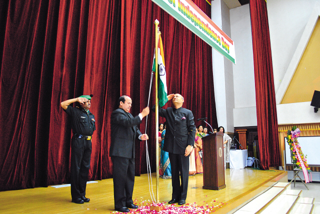 Indian Ambassador Vishnu Prakash (right) salutes the Indian flag as it is raised in honor of the country’s 66th Independence Day in Seoul on Wednesday. (Robert Lee/The Korea Herald)