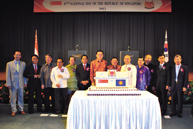 Singaporean Ambassador Peter Tan (sixth from right) and Knowledge Economy Minister Hong Suk-woo (center) pose with other ASEAN Ambassadors to commemorate the country’s Independence Day in Seoul on Tuesday. (Robert Lee/The Korea Herald)