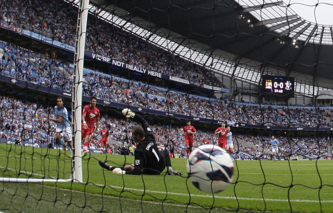 Manchester City’s Carlos Tevez (left) scores past Southampton goalkeeper Kelvin Davis on Sunday.   AP-Yonhap News