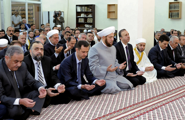 Syrian President Bashar Assad performs Eid prayers in the Hamad Mosque in Damascus on Sunday.   AP-Yonhap News