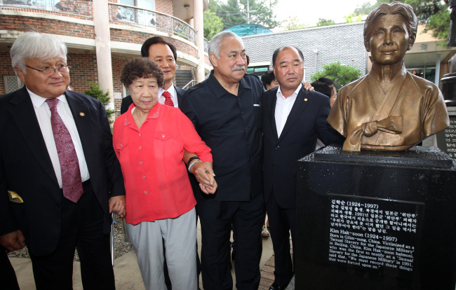 U.S. Representatives Michael Honda (left) and Eni Faleomavaega (second from right) look at the statue of late Kim Hak-soon, a victim of Japan’s sexual enslavement of women during World War II, at a home for Korean former sex slaves located in Gwangju on Monday.   Yonhap News