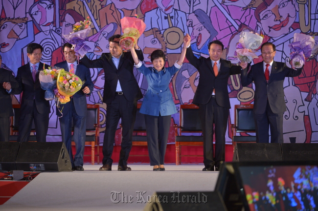 The ruling Saenuri Party’s contenders in the party’s presidential primary join hands at the party’s national convention on Monday after former party chief Rep. Park Geun-hye won the ticket. From left are Gyeonggi Governor Kim Moon-soo, former Incheon Mayor Ahn Sang-soo, former South Gyeongsang Governor Rep. Kim Tae-ho, Park, former presidential chief secretary Yim Tae-hee, and Chairman Hwang Woo-yea.   Park Hyun-koo/The Korea Herald