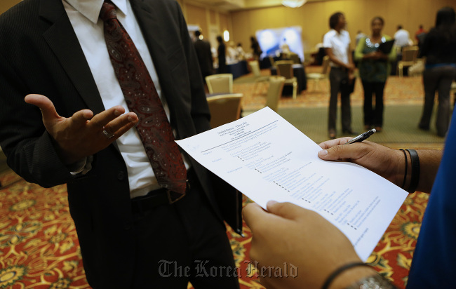 A recruiter reviews a job seeker’s resume during a Coast to Coast Career Fairs event in Houston, Texas.    Bloomberg