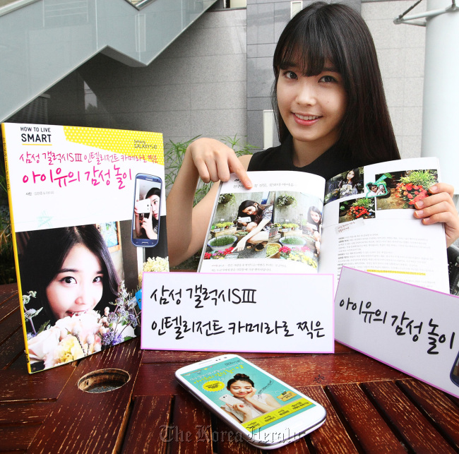 IU poses with her book. Samsung Electronics