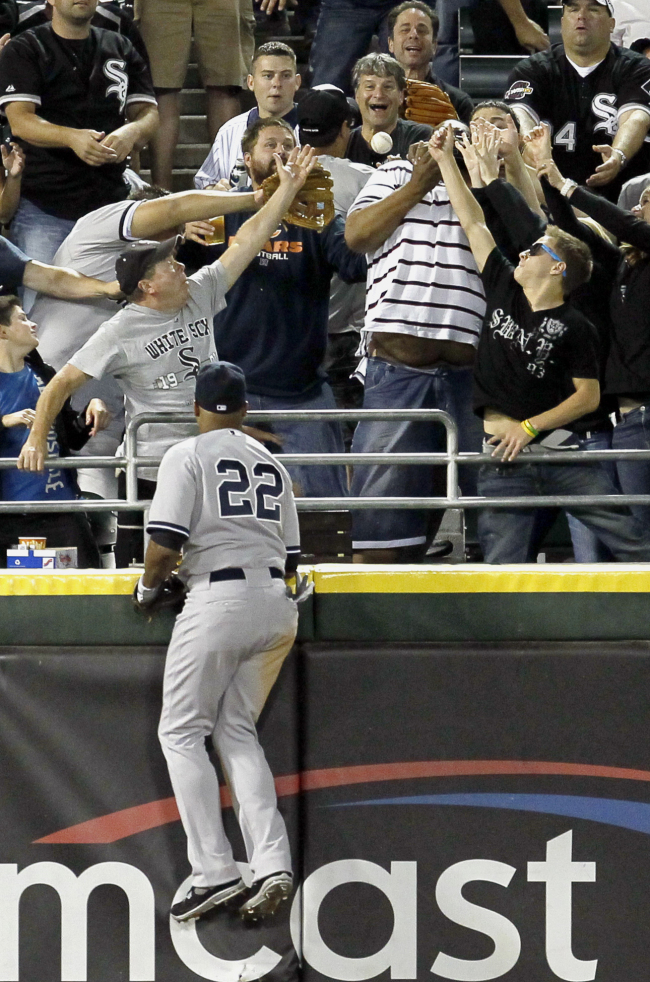 New York Yankees left fielder Andruw Jones watches as fans try to catch Chicago White Sox first baseman Paul Konerko’s home run in the fourth inning.   AP-Yonhap News