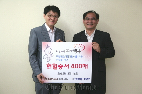 Daesang Holdings executive Joo Hong (left) poses with Chun Jin-wook, secretary-general of the KACLC, after delivering 400 blood donor cards to the association.   Daesang