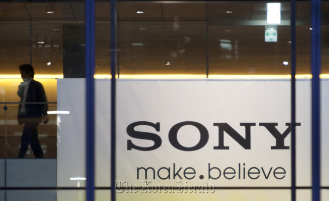 A man walks near a banner bearing the Sony Corp. logo at the company’s headquarters in Tokyo.   Bloomberg