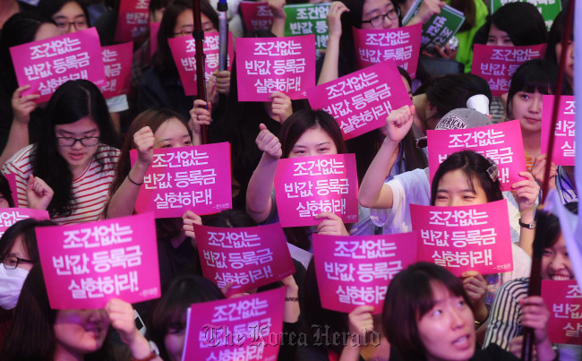 Students participate in a rally calling for halved tuition fees at Cheonggye Square in Seoul in June 2011.   Park Hae-mook/The Korea Herald