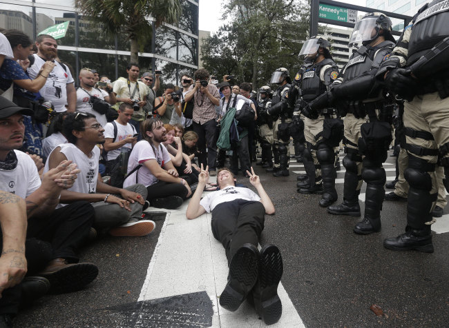 A demonstrator lays on the street during a march through the streets of Tampa, Florida, to protest the Republican National Convention on Monday.   AP-Yonhap News