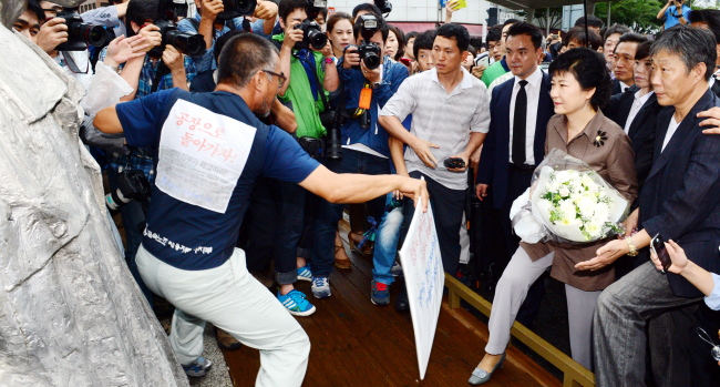 The ruling Saenuri Party’s presidential candidate Park Geun-hye (second from right) is blocked by protesting union members of Ssangyong Motors and officials during her visit to the foundation of late workers’ rights activist Jeon Tae-il in Jongno, Seoul, Thursday. (Park Hyun-koo/The Korea Herald)