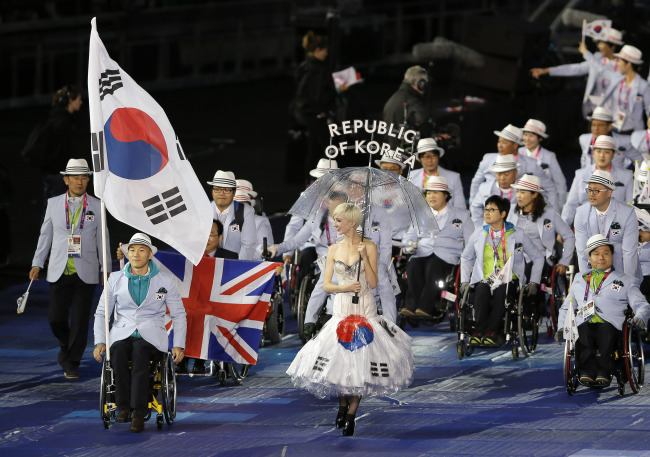 South Korea’s flag bearer wheelchair marathonian Kim Gyu-dae during the opening ceremony for the 2012 Paralympics in London on Wednesday.   AP-Yonhap News